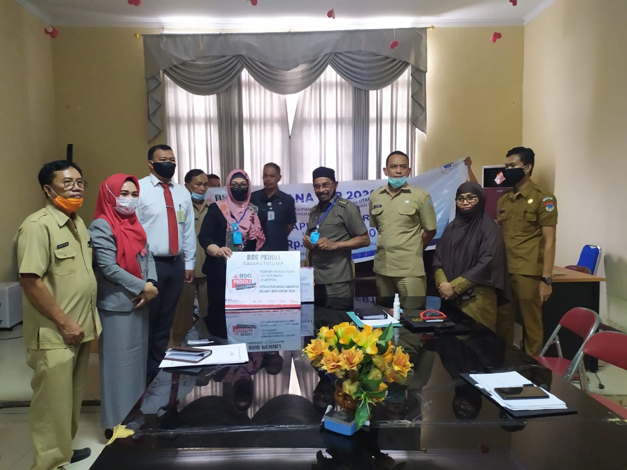 Foto-Kepala Cabang Bank SulutGo Tutuyan, Diana Mokoginta menyerahkan secara simbolis bantuan APD kepada Bupati Boltim Sehan Landjar, SH.  bertempat di kantor bupati kabupaten Bolaang Mongondow Timur