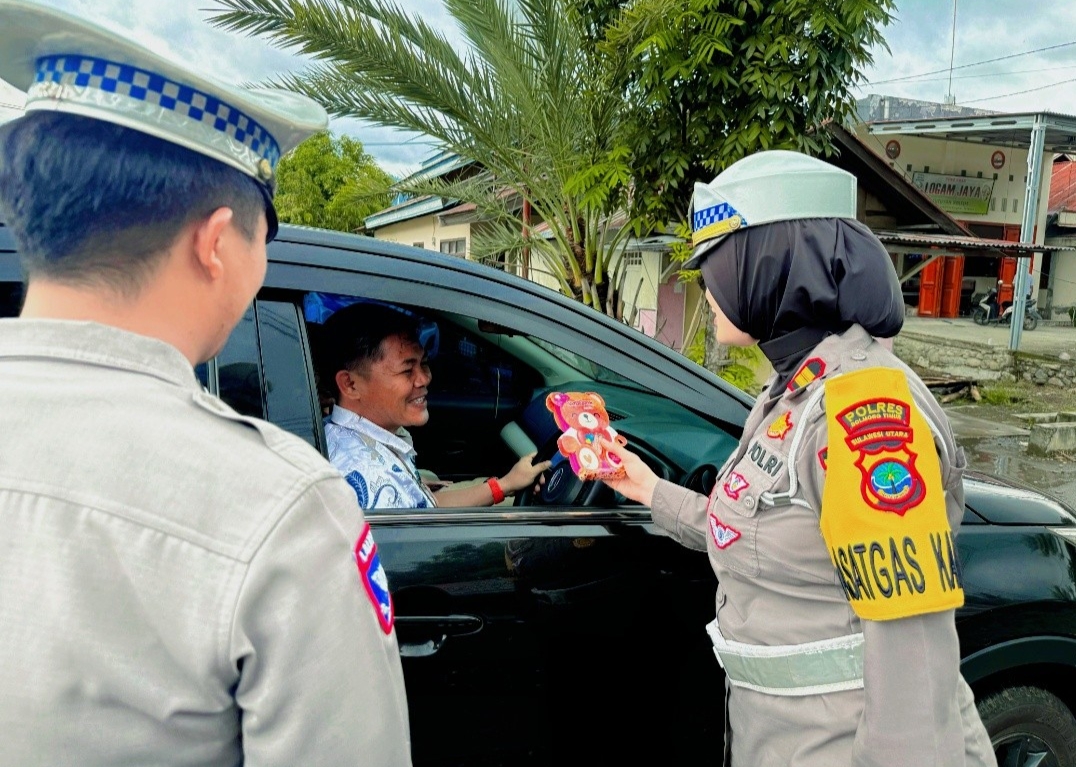 Foto:Kasat Lantas Polres Boltim Iptu Fitri Nugrahani, S.Tr.K.,Membagikan Hadiah kepada Pengendara yang Taat Berlalu Lintas